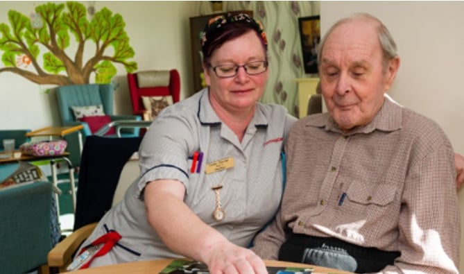 A Cornwall Care member of staff helps an elderly care home resident.