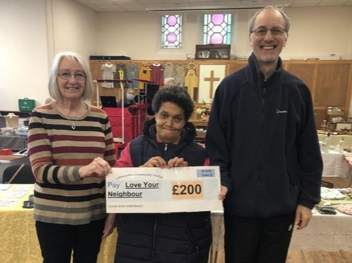 Jackie Tyler (centre) representing the Community Market presenting a cheque to Val and Mike Carpenter of Love Your Neighbour