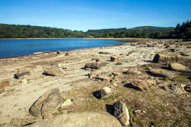 The Burrator Reservoir in Devon, which is 44% full. 6th August 2022. See SWNS story SWNJdry; Shocking images show a shrinking reservoir less than half full as a result of the UK's staggering heatwave. With no rain in sight, the drone shots reveal Burrator water reservoir in Devon, which is drying up with water levels currently at just 44%.  Last month temperatures hit 40.2 degrees Celsius in parts of the UK and red extreme heat national severe weather warnings were issued. The diminishing water volumes are due the intense British heatwave and there is no rain expected for a few weeks. Water levels at Burrator are already at its lowest in decades, and Dartmoor locals believe the drought will bring about the remains of a long-lost "drowned village", which they expect to emerge from the depths. 