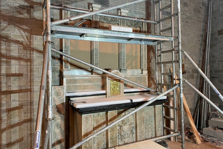 Behind scaffolding, the altar begins to take form from the 22 crates in which it arrived
