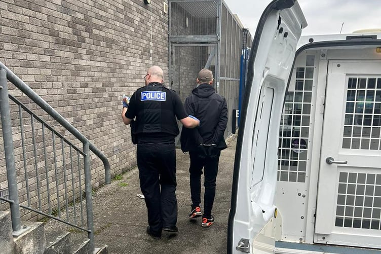 One of the arrested individuals being led away by Police