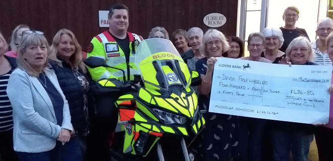 Members of St Giles on the Heath Women’s Guild present a cheque for £486.80 to Tony Ewens of Devon Freewheelers