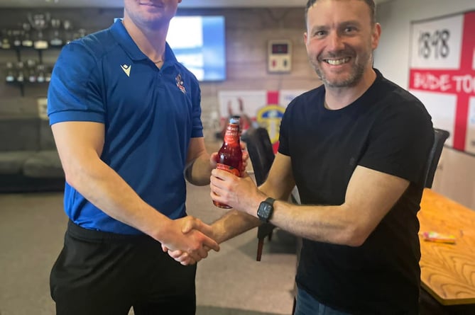 Bude Town Reserves captain James Wheeler receives his man of the match following Saturday's win by club legend, Ian Adams.