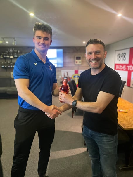 Bude Town Reserves captain James Wheeler receives his man of the match following Saturday's win by club legend, Ian Adams.