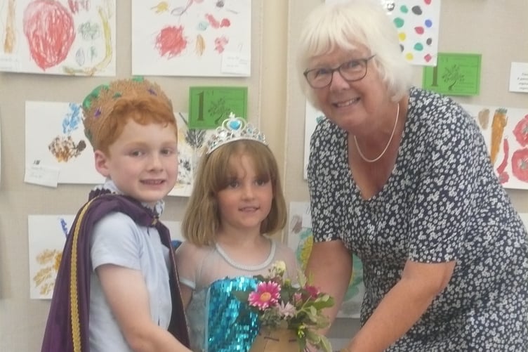 Rev Marilyn Elliott who opened the Linkinhorne Horticultural Show at the Parish Hall in Upton Cross, being presented with a floral gift from Rilla Mill Carnival King, Harry Davy and Carnival Queen, Merryn Davy
