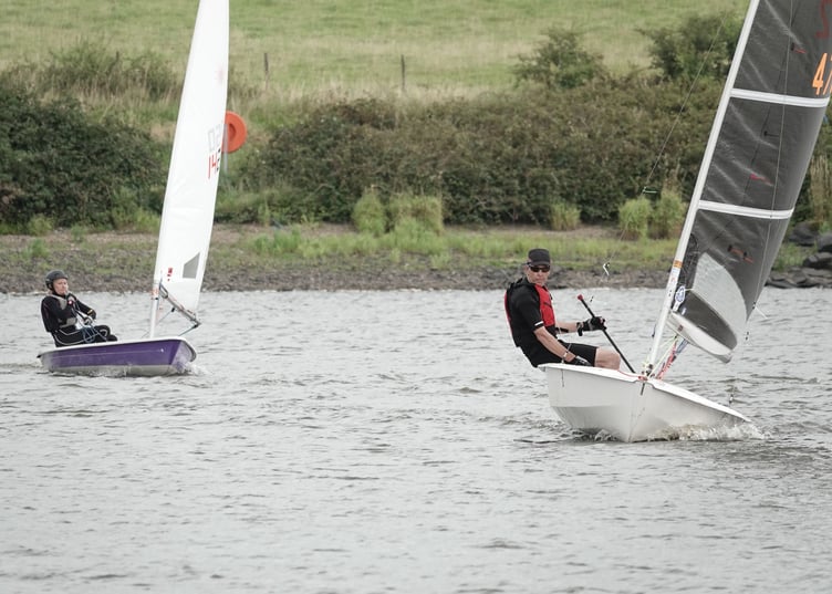 Dave Perrett's Solo with a full-sized sail leads Jane Anderson's Laser flying its smallest sail. Applying the handicaps reversed their positions. Picture: Mandy Pollard