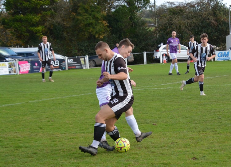 Holsworthy's Gavin Carter, pictured battling for the ball, had an eventful afternoon, scoring before being sent off for a two-footed lunge. Picture: Rodney Parrish
