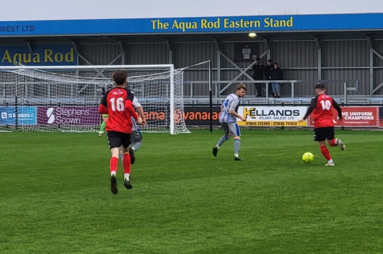 Holsworthy centre-half Sam Hill prepares to try and tackle Truro City's Alfie Flack. Picture: Holsworthy AFC