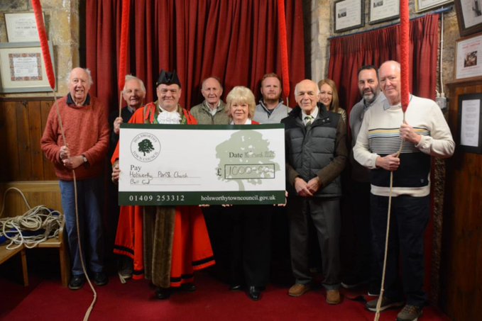 Cllr Nigel Kenneally, mayor of Holsworthy, presenting the cheque to the Holsworthy Bellringers group (Picture: Holsworthy Town Council)