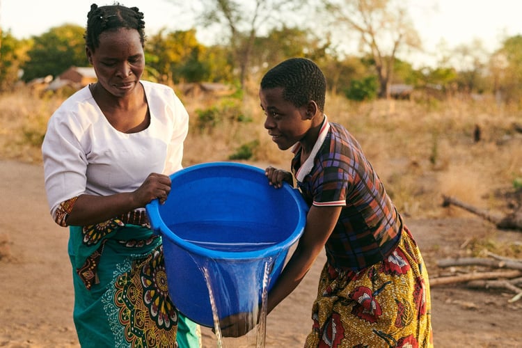 Sileni, 33, and her daughter, Merifa, 15, washing clothes with clean water in M’doko, Malawi.