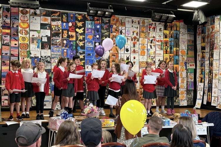 Artwork from the children's art competition forms the backdrop for performances on the Callington town hall stage.