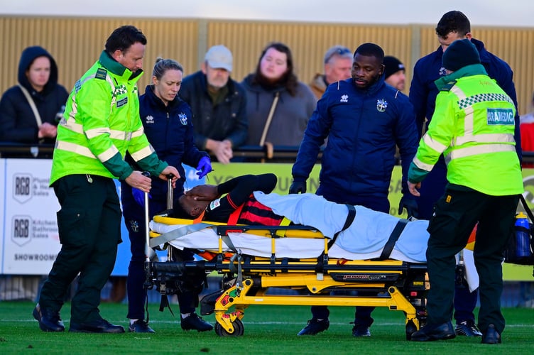 Dominic Johnson-Fisher of Truro City goes down injured and gets treatment, but is stretchered off during the National League match between Truro City and Sutton United at Truro City Stadium on 22 December 2025 Photo: Phil Mingo/PPAUK