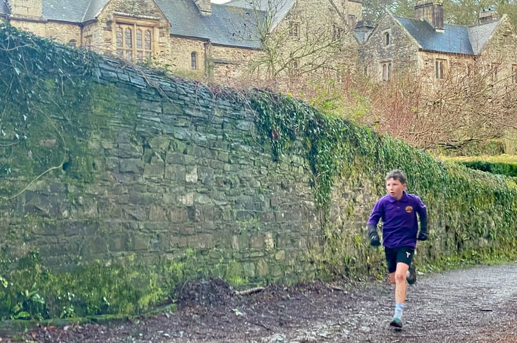 Jacob Sweeney from Bishop Cornish School runs alongside the picturesque Cotehele House